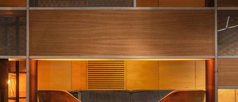 A modern interior with a built-in fireplace, wooden paneling, and a seating area.