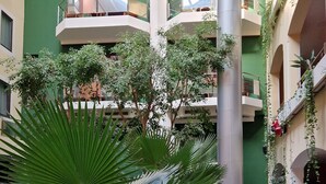 A multi-level atrium with balconies, potted plants, and seating areas. - Ararat Hotel (Yerevan)