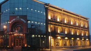 A hotel with a modern glass facade and a classic building with illuminated windows. - Ararat Hotel (Yerevan)