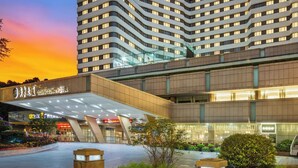 Een modern hotel met een opvallende entree, meerdere verdiepingen en een groot bord waarop Guangzhou Hotel staat.