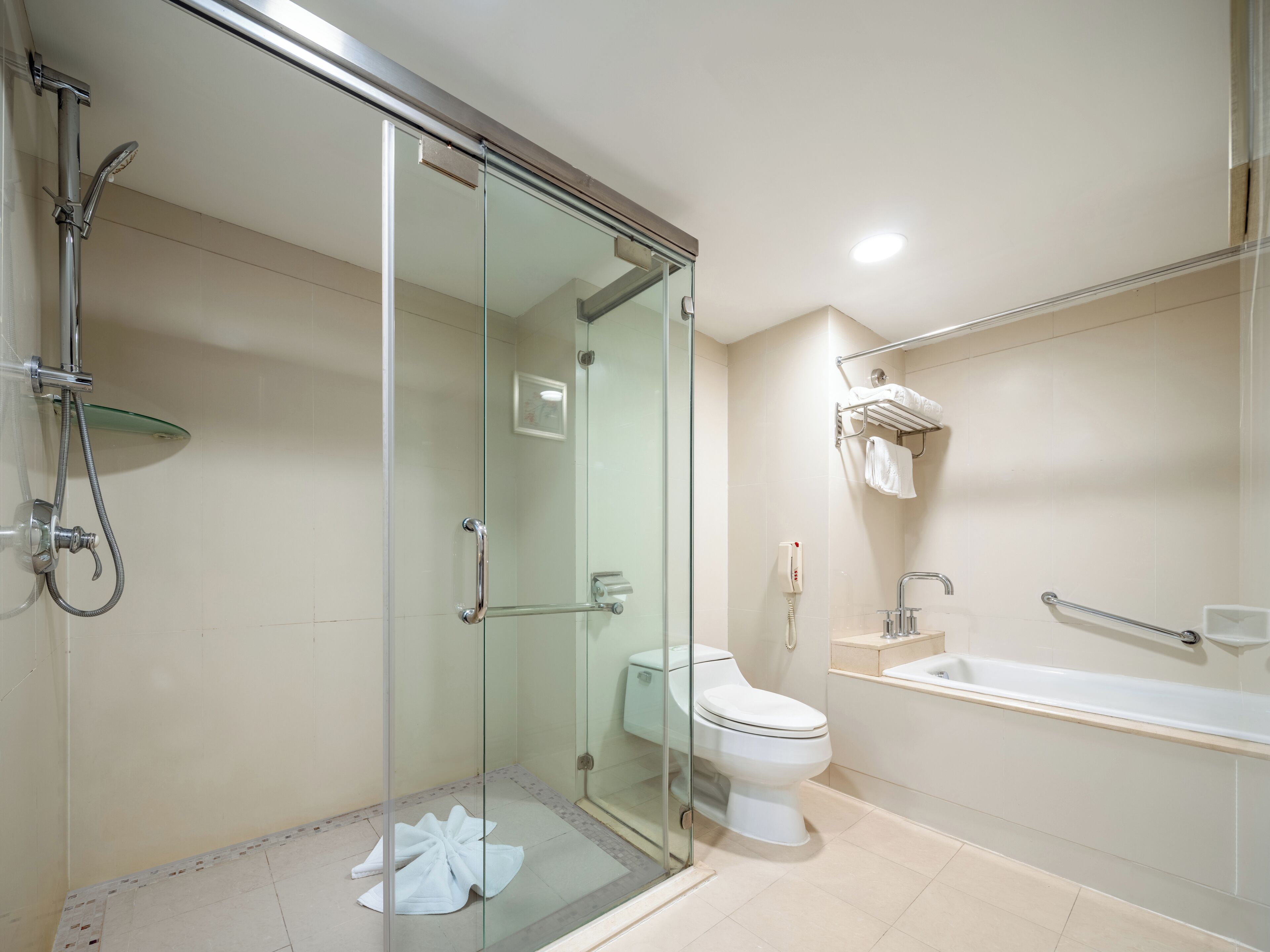 Un baño moderno con ducha envuelta en vidrio, inodoro y bañera.