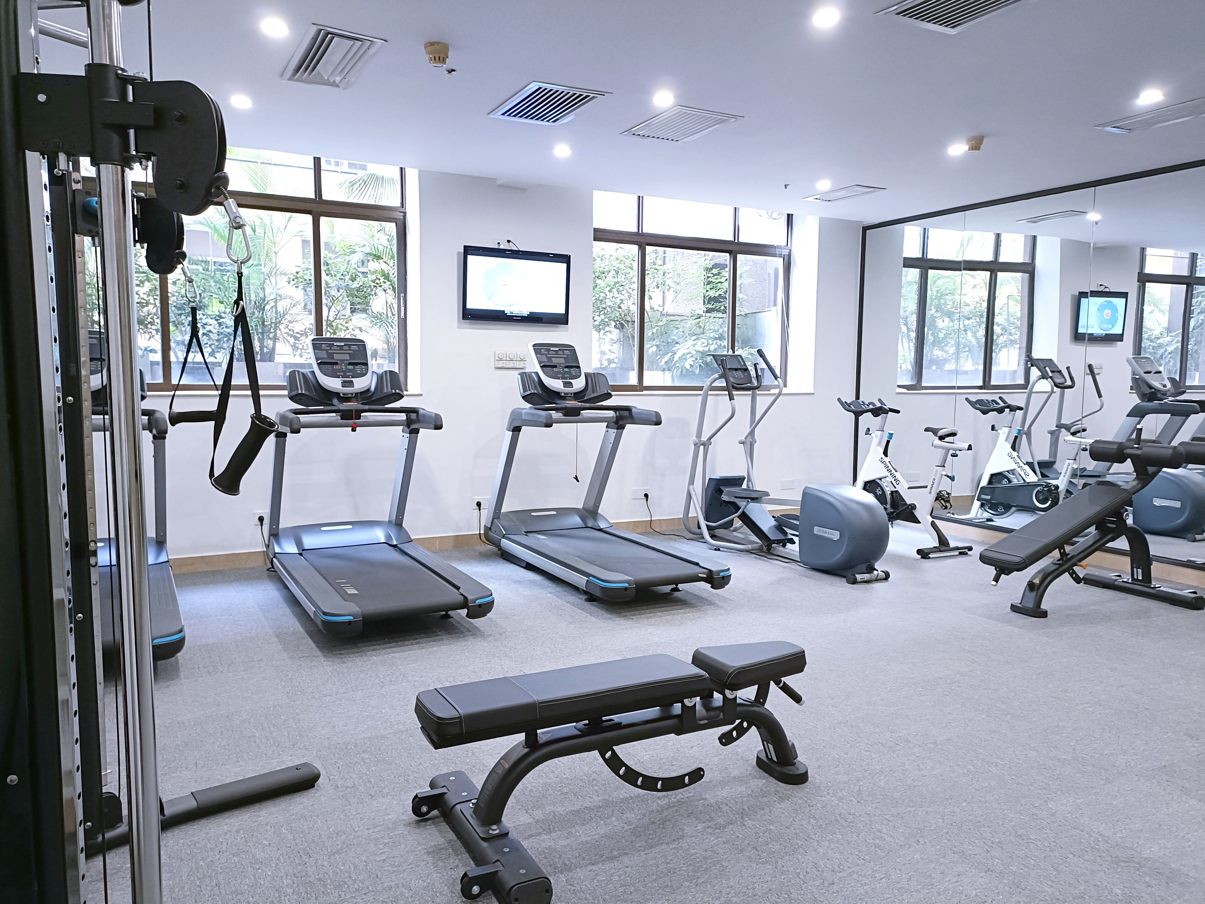 Ein Fitnessstudio mit Laufbändern, Crosstrainern und Gewehrbänken.