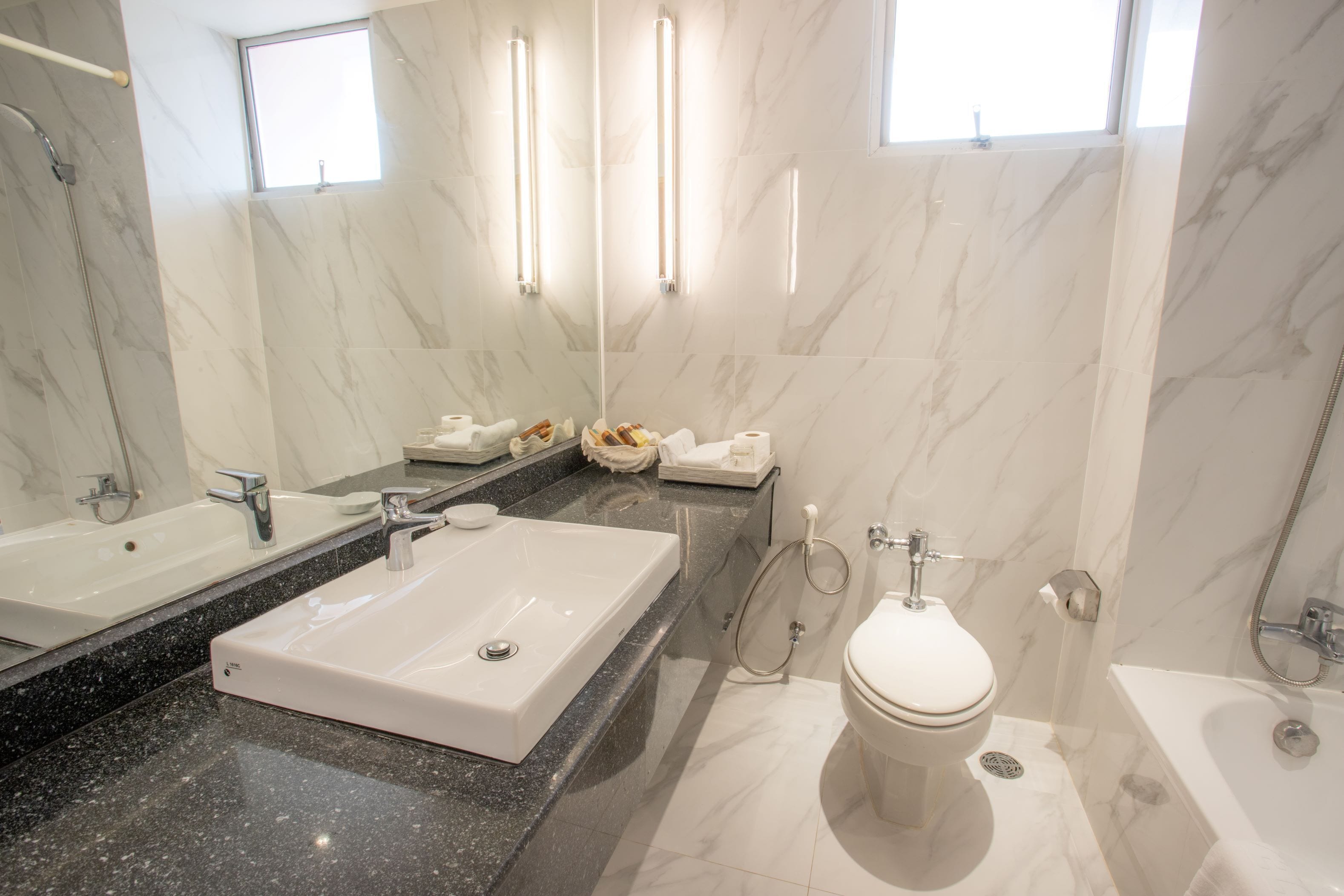 Un baño moderno con un lavamanos grande rectangular, un inodoro y una bañera.