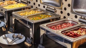 A buffet with various food options and serving utensils. - LH Vintage Design Hotel Sax (Prague)