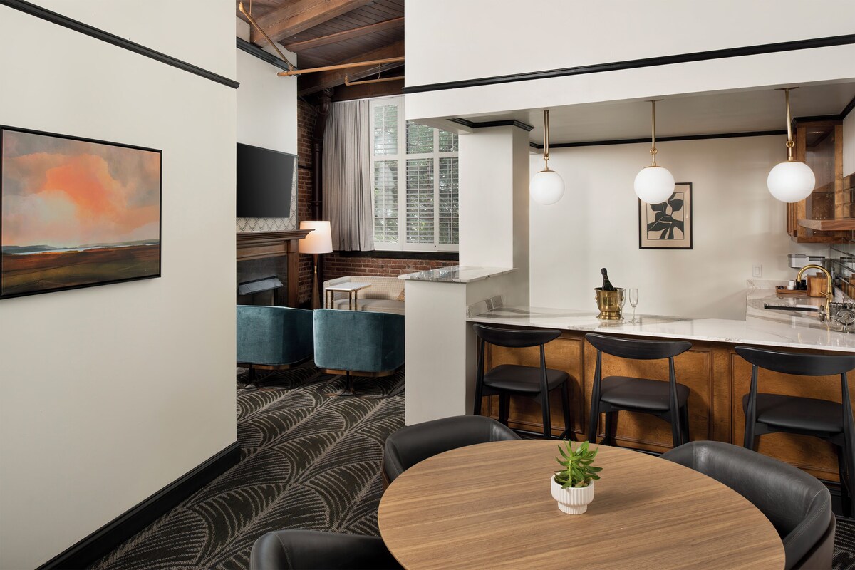 A modern kitchen with a central island, bar stools, and pendant lighting.