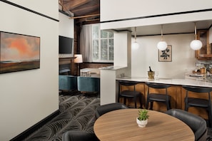 Una cocina moderna con una isla central, taburetes de bar e iluminación colgante.