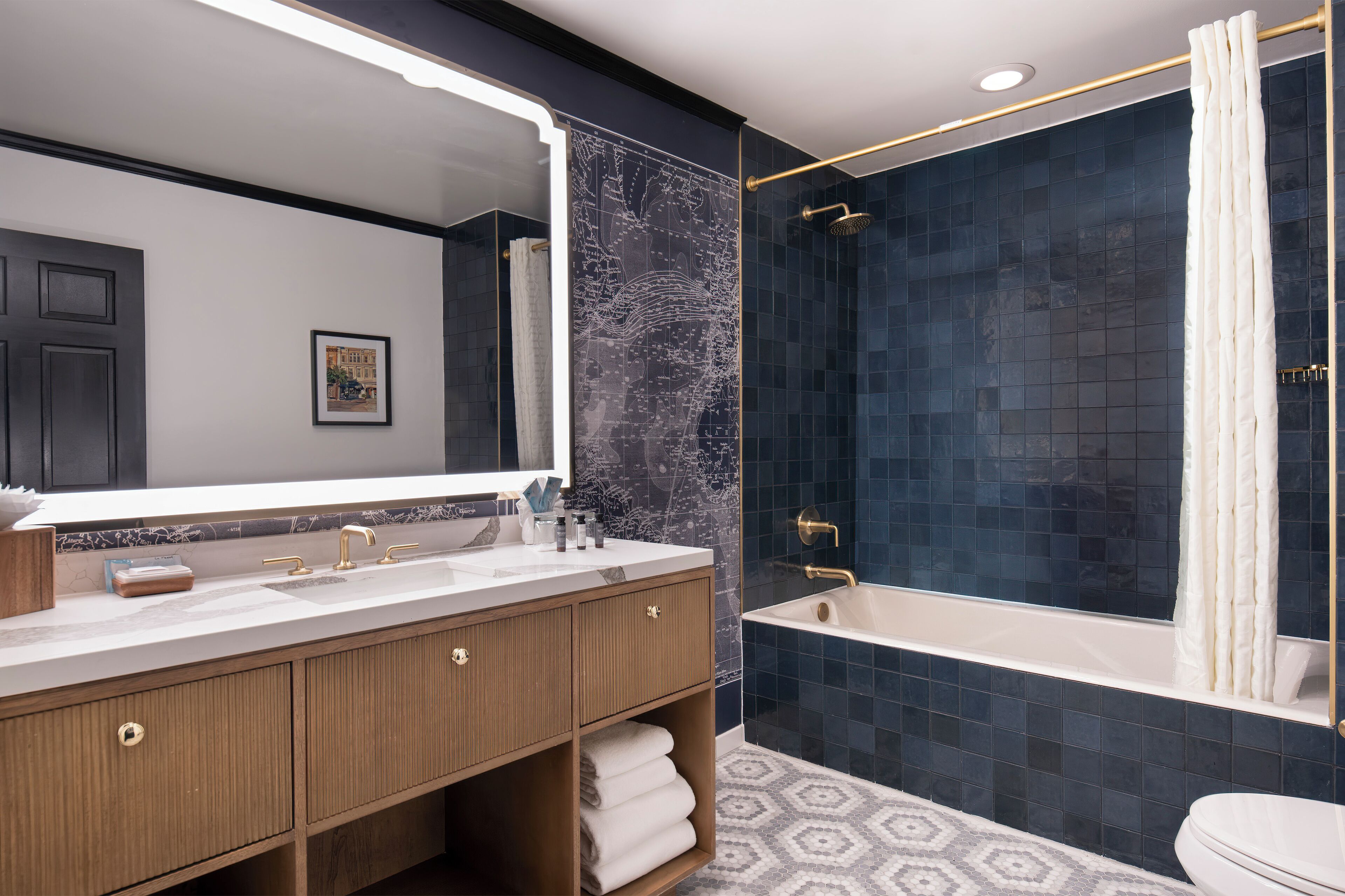 Un baño moderno con tocador doble, un espejo grande, bañera y zona de ducha.