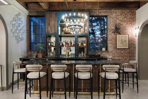 Zona de bar con pared de ladrillo, una lámpara de araña y un mapa de Charleston.