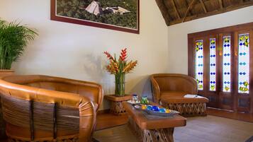 A room with two leather chairs, a wooden coffee table, and a potted plant.