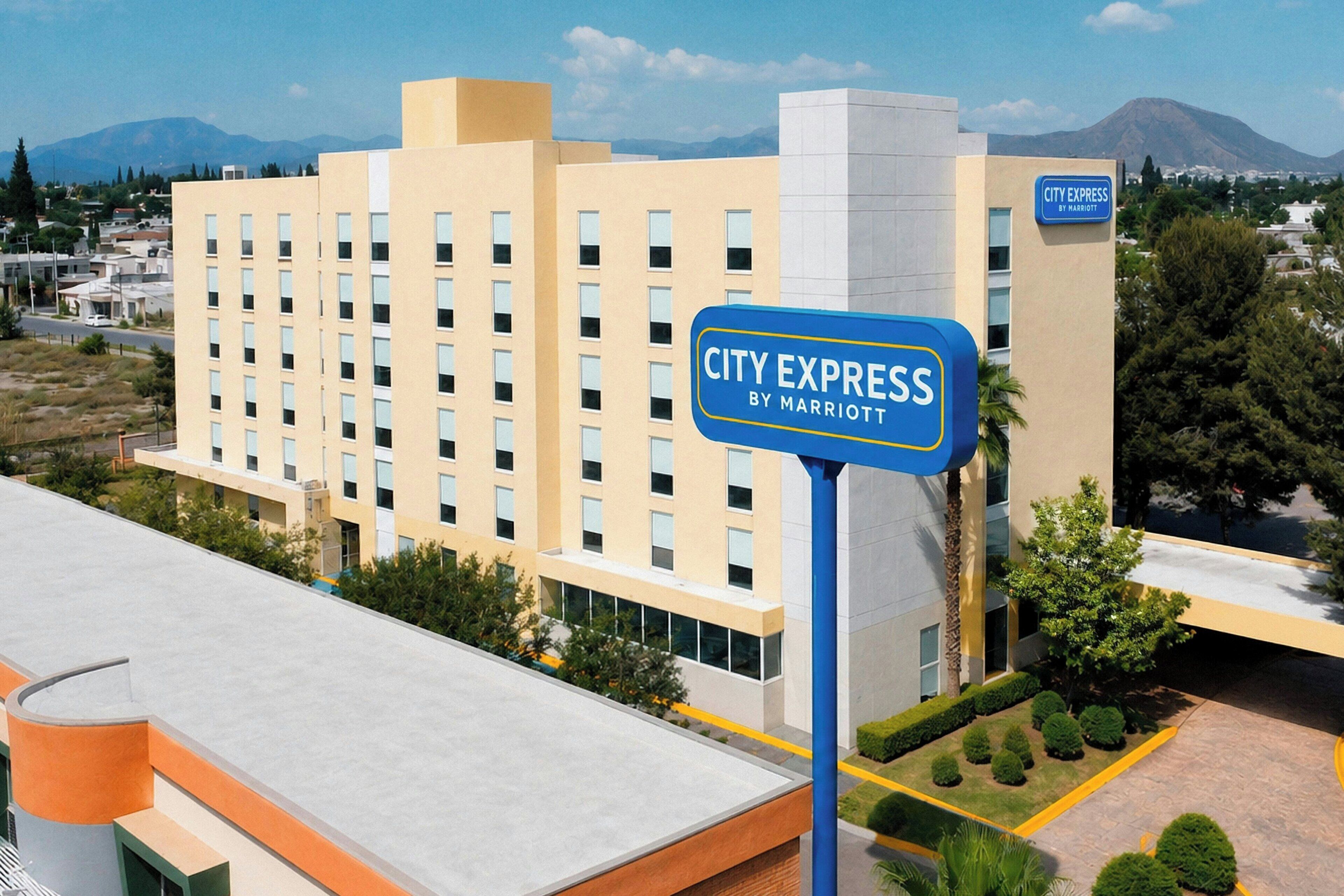 A hotel named City Express by Marriott with a modern architectural design, featuring a prominent signboard.