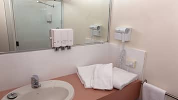A bathroom with a sink, mirror, towel rack, and hairdryer.