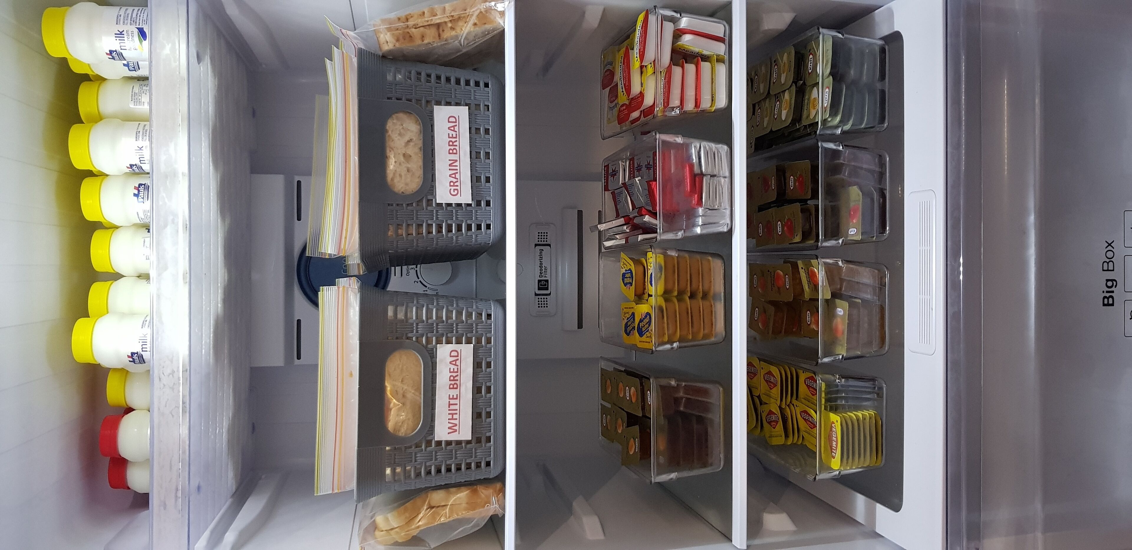 Un frigorífic amb prestatges organitzats que contenen diferents aliments i condiments.