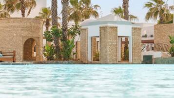 Una piscina al aire libre, camas de piscina gratis, sombrillas