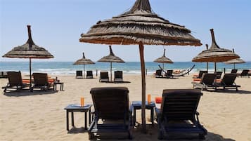 Nyilvános parton, fehér homok és strandlepedők