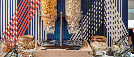 Una exhibición de alimentos con botes y recipientes de granola y otros bocadillos.