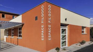 Um edifício moderno com 'ESPACE FILG GOOD' escrito verticalmente na fachada.