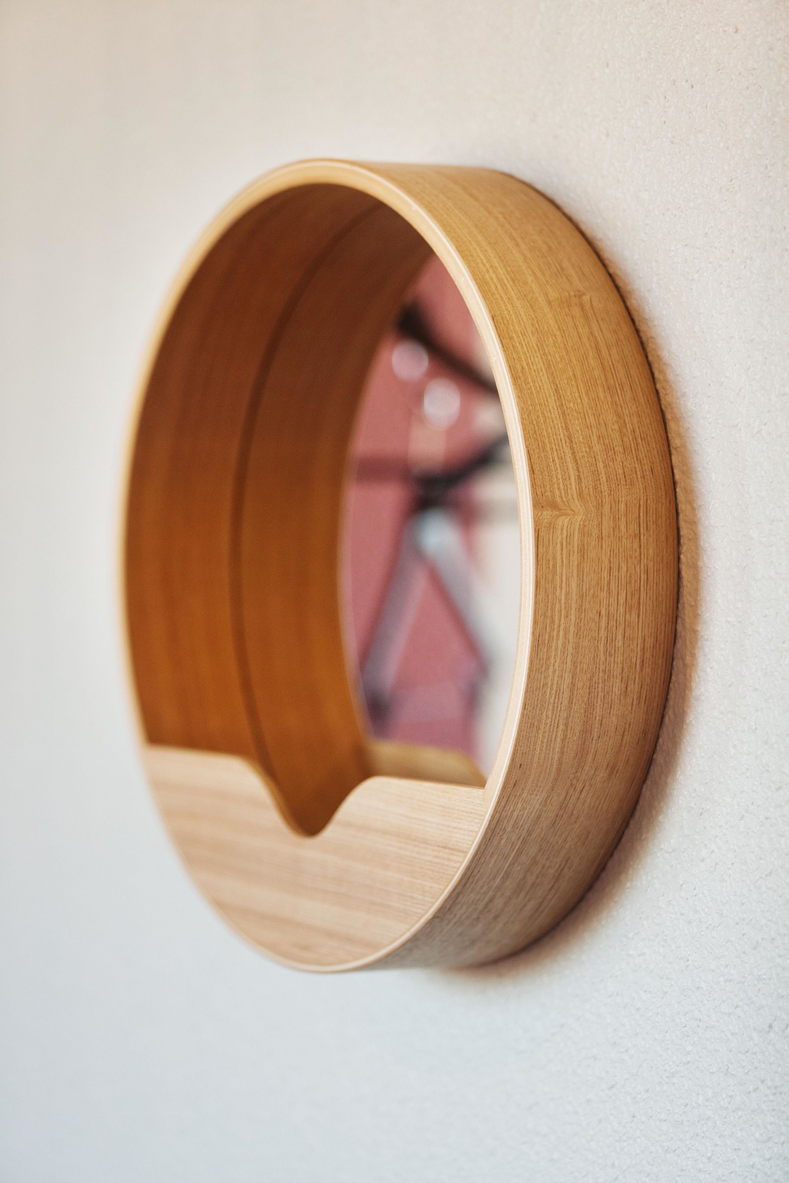 A wooden wall-mounted shelf with a circular opening.