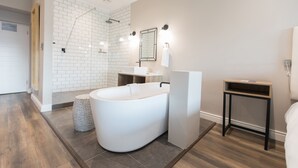 Een moderne badkamer met een vrijstaand bad, een douchegedeelte en een wastafel met spiegel.
