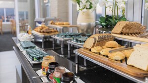 Een ontbijtbuffet met diverse producten, zoals brood, gebak en toevoegingen.
