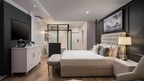 Een moderne slaapkamer met een groot bed, nachtkastjes, een kledingkast en een televisie.