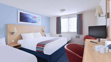 A hotel room with a large bed, a desk with a TV, and a red chair.
