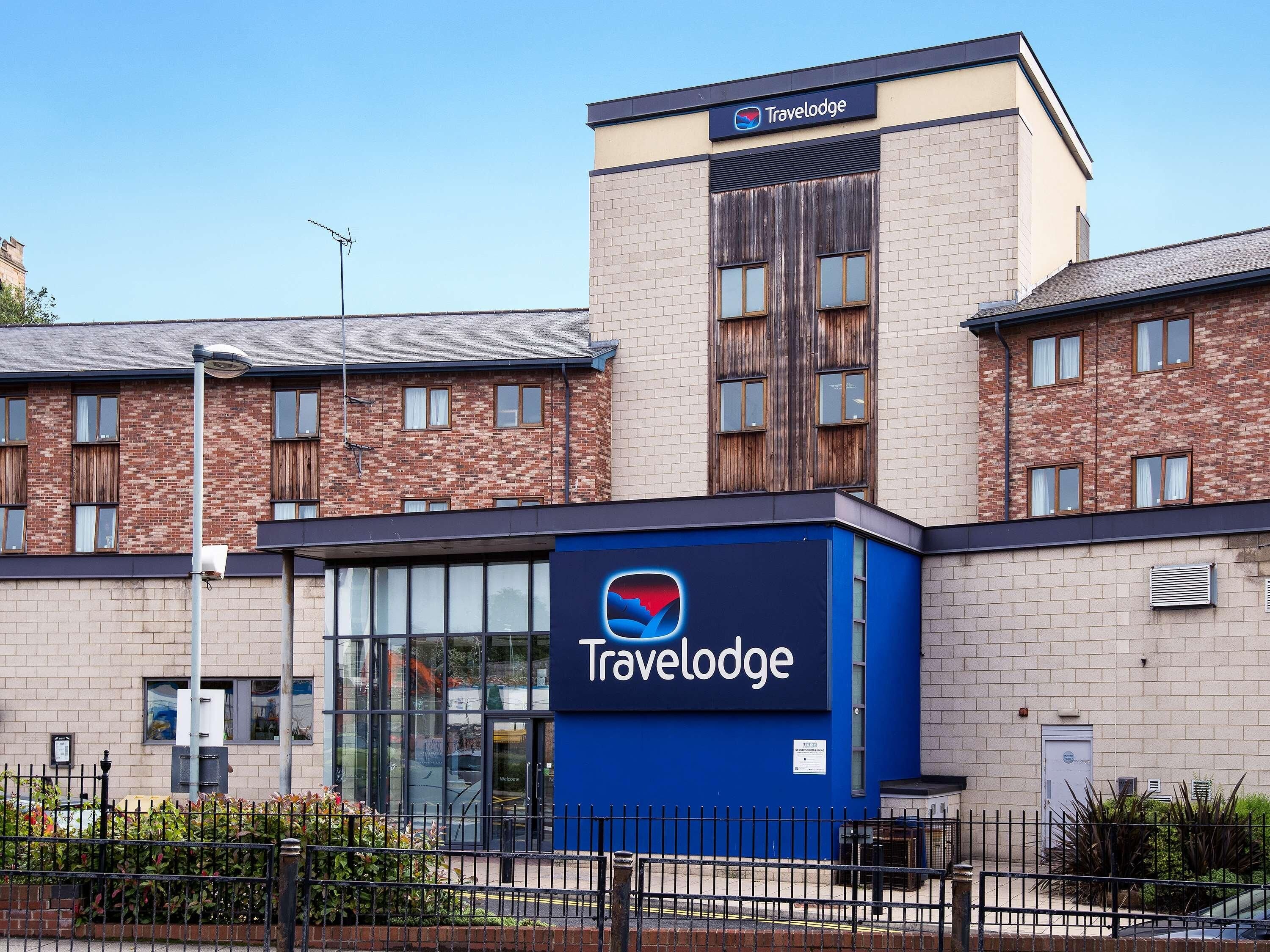 A Travelodge hotel with a modern facade, large windows, and a prominent blue sign.