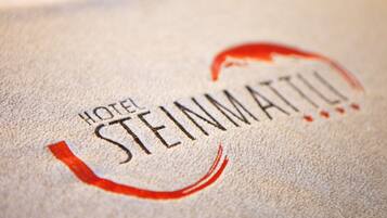 A close-up of a hotel name, HOTEL STEINMATTU, on a textured surface.