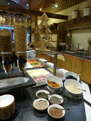 A buffet with various food options including grains, meats, and vegetables. - Hotel Steinmattli (Adelboden)
