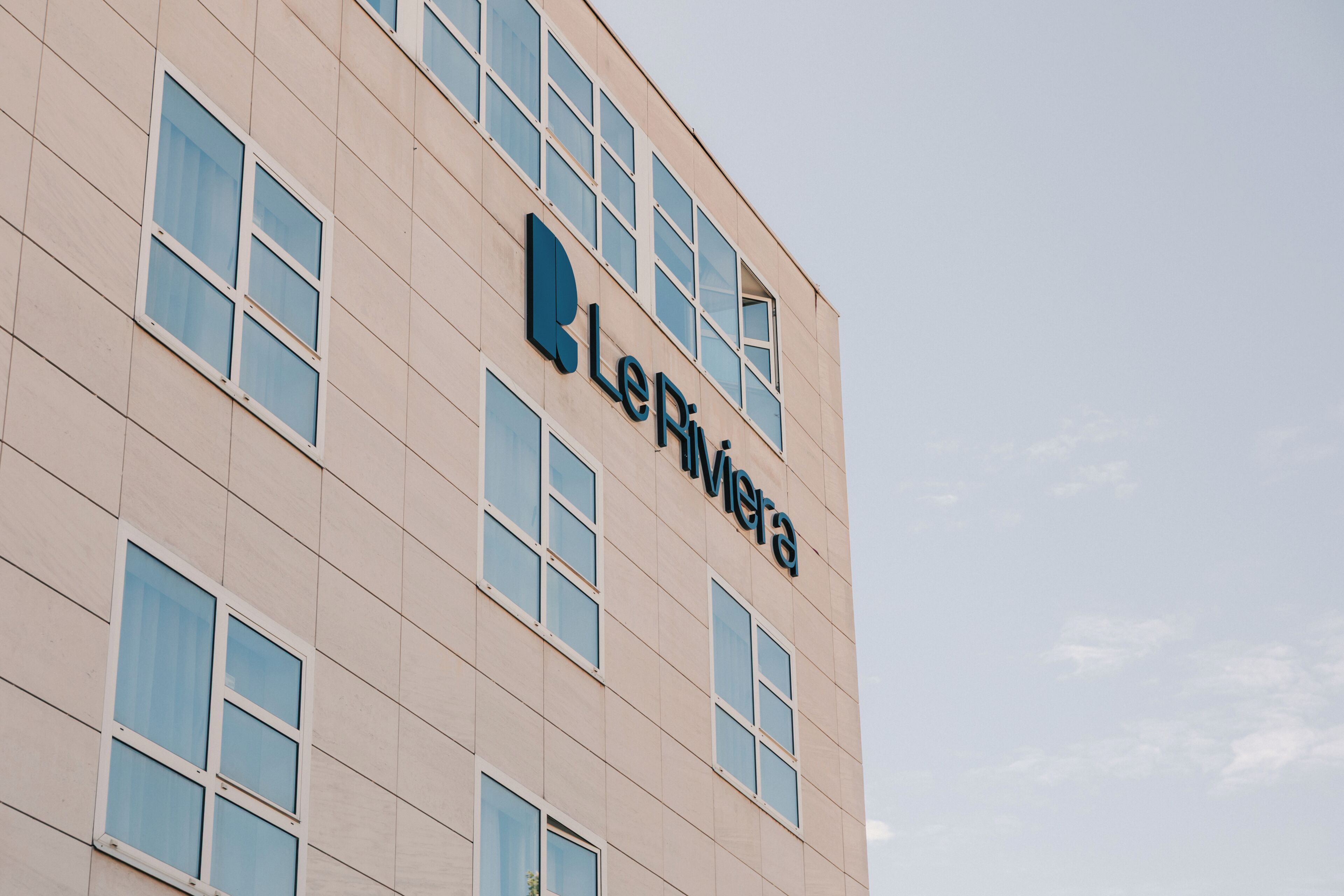 A building with multiple windows and a sign that reads 'LeRiviera'.