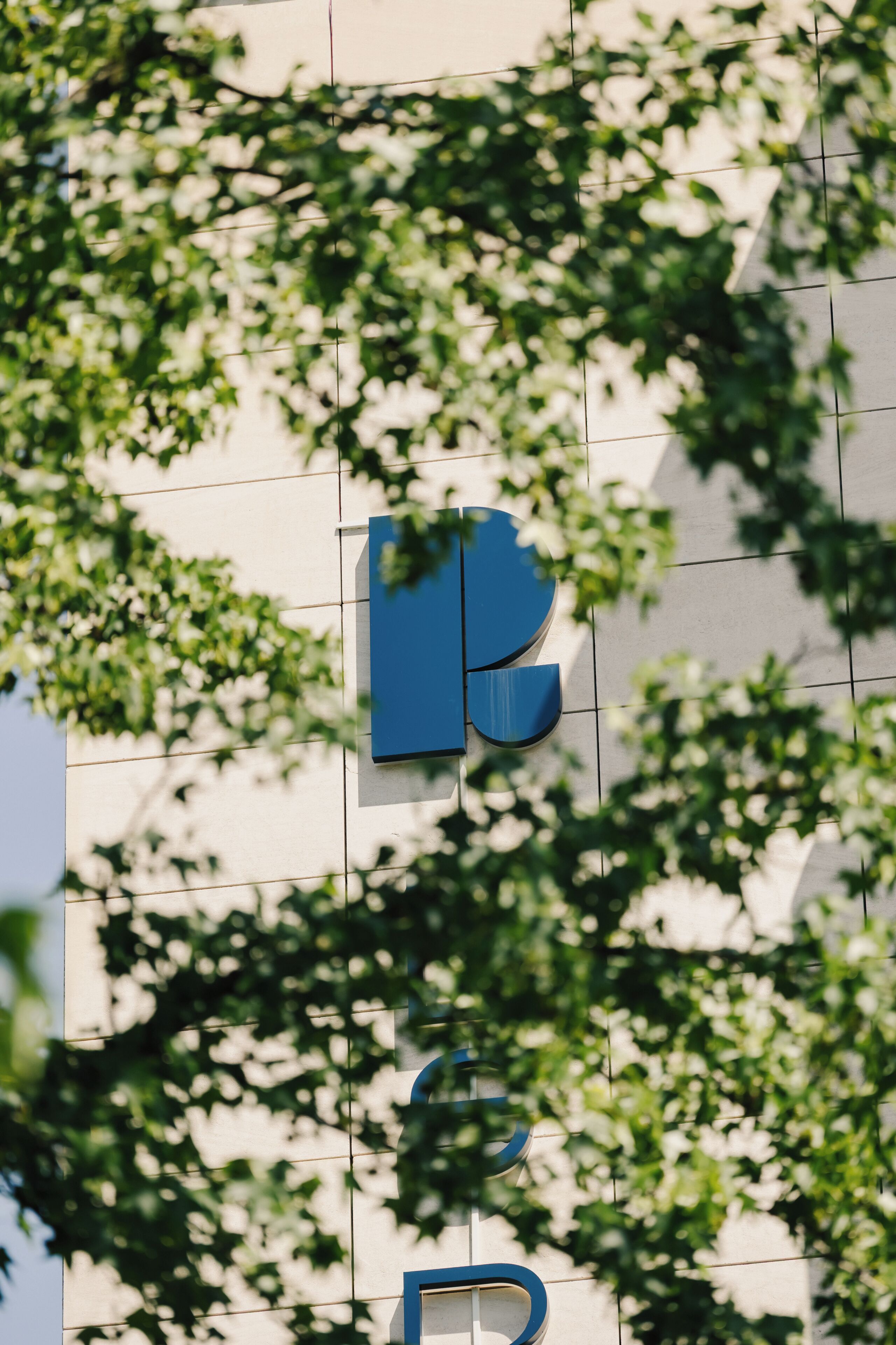 Une façade d’immeuble ornée d’un logo bleu et d’un motif en quadrillage.