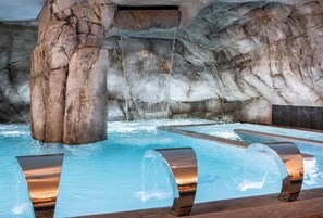 A pool area with a waterfall feature and a rocky backdrop. - Riviera – Hotel, Restaurant & Spa (Aix-les-Bains)