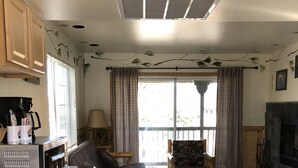A compact living space with a kitchenette, a sofa, a small table, and a fireplace. - Fireside Lodge (Big Bear Lake)