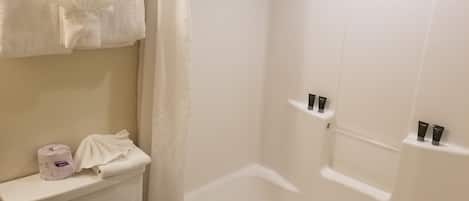 Une salle de bain avec des toilettes, un rideau de douche et une baignoire.