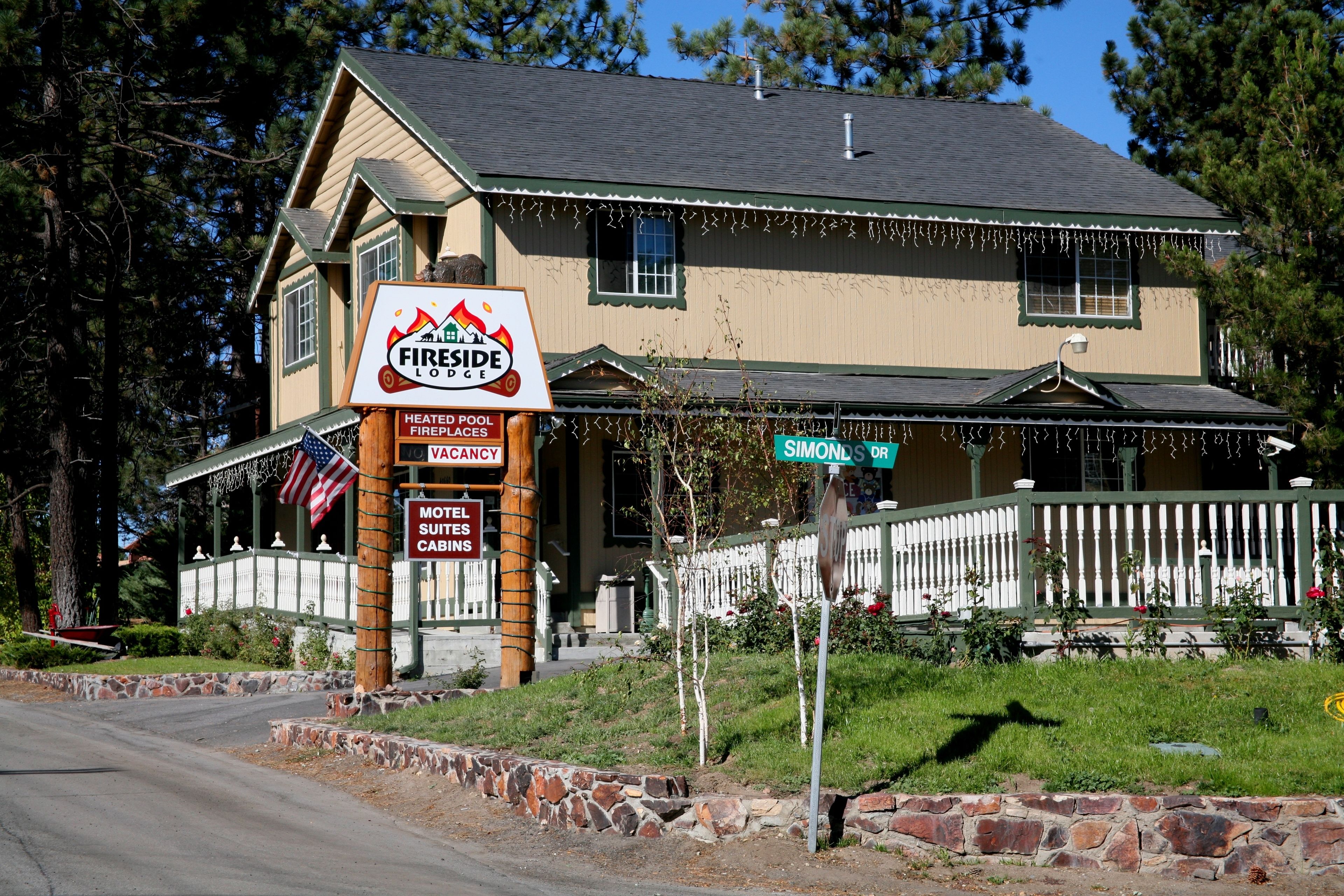 Un bâtiment portant une enseigne « Fireside Lodge », indiquant la présence de foyers près de la piscine chauffée, le nombre de chambres disponibles et la présence de chalets de motel.
