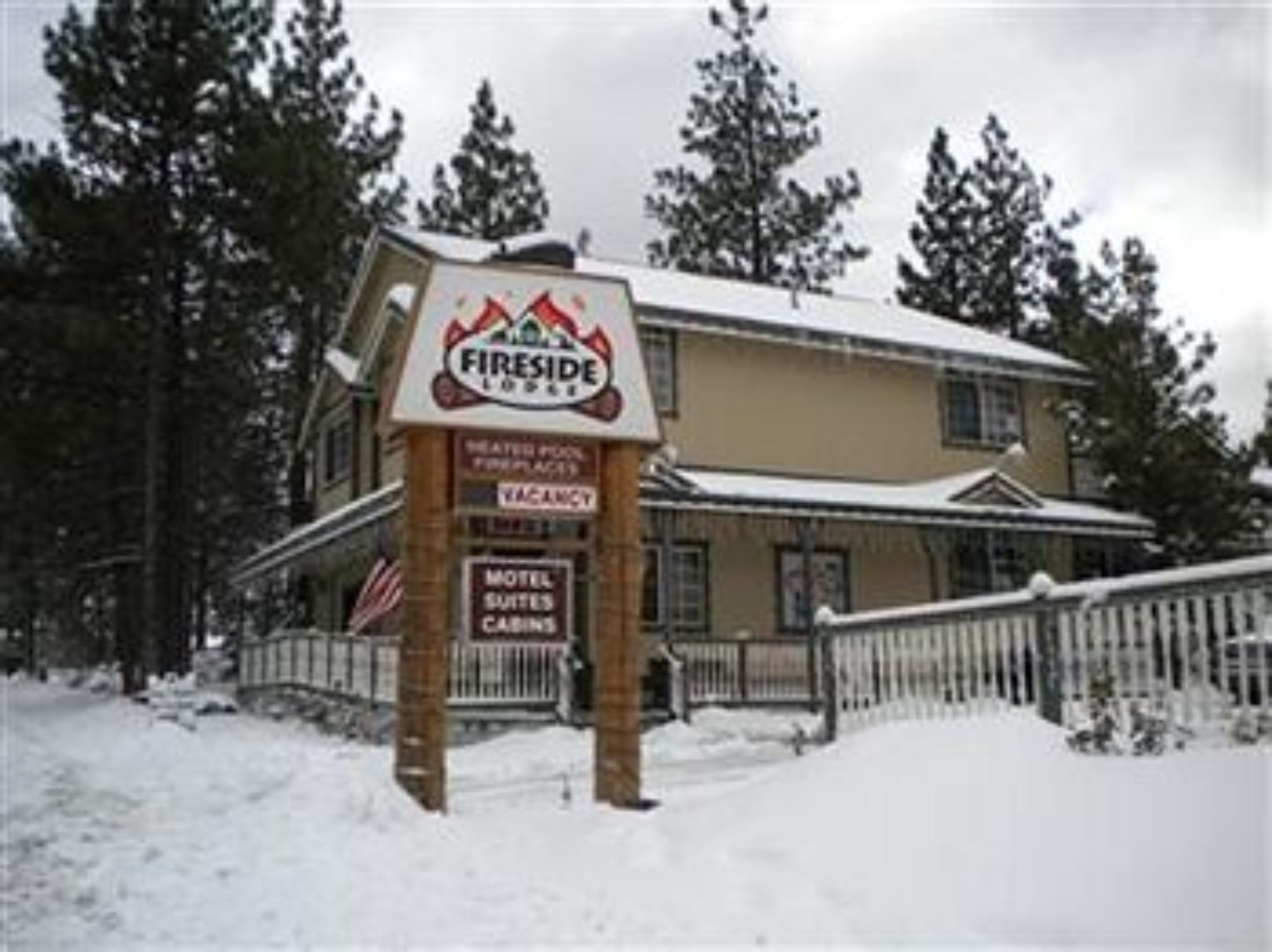 Señal de Fireside Lodge con un aviso de 'Disponibilidad' y un cartel que indica 'Motel Suites'.