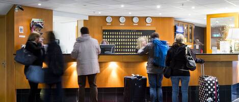 A reception area with a message board, a clock, and a counter.