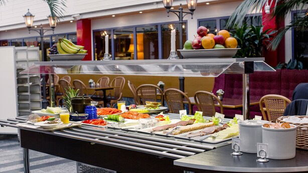 A buffet setup with various food items and a seating area in the background. - 2Home Stockholm South (Arsta)