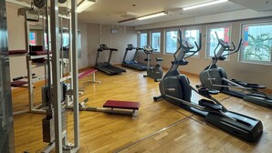 A gym with treadmills, elliptical machines, and a weightlifting area. - 2Home Stockholm South (Arsta)