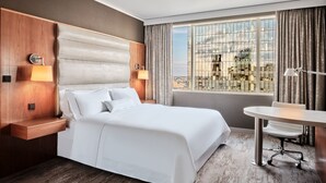 A modern hotel room with a large bed, a desk, and a view of the city through a large window. - The Westin Warsaw (Warsaw)