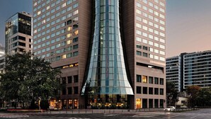 A modern hotel with a distinctive curved glass facade and multiple floors. - The Westin Warsaw (Warsaw)