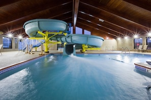 An indoor swimming pool with a water slide, wooden ceiling, and tiled walls. - AmericInn by Wyndham Shakopee Near Amphitheater (Shakopee)