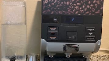 Máquina de café com várias opções de preparo e um dispensador de água.