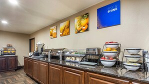 A buffet setup with various food items and a 'RISE & SHINE' sign on the wall. - Comfort Inn Story City (Story City)