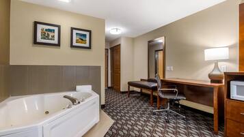 A hotel bathroom with a bathtub, a sink, a mirror, and a chair.