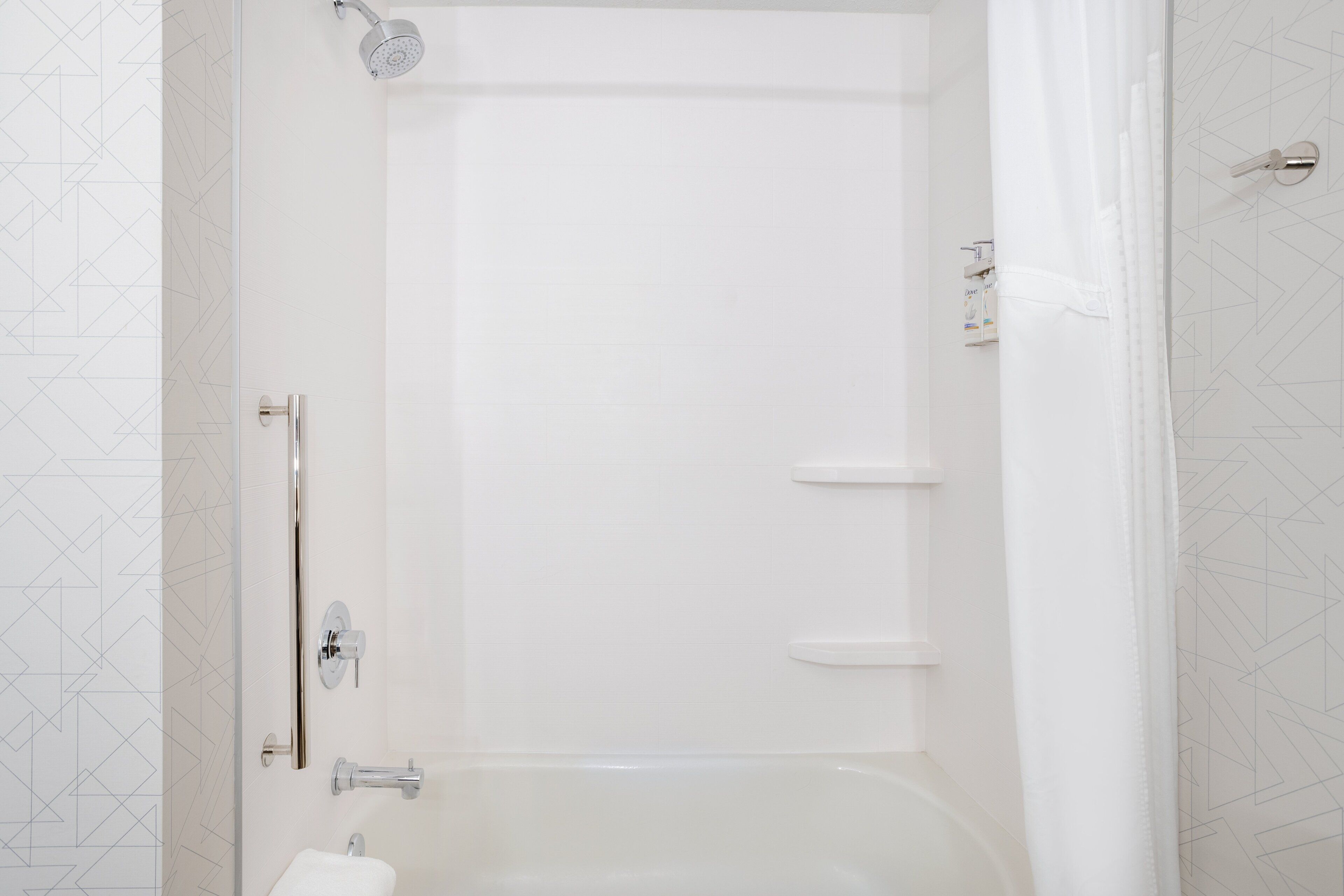 A modern bathroom with a bathtub, a showerhead, and a toilet.