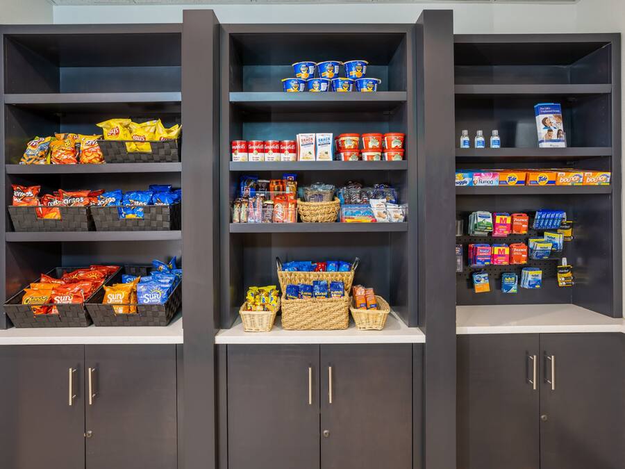 Un depósito de almacenamiento con varias estanterías que contienen aperitivos, bebidas y artículos para el hogar.