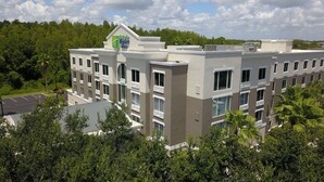 A multi-story Holiday Inn Express Suites building with a modern design, featuring balconies and large windows.