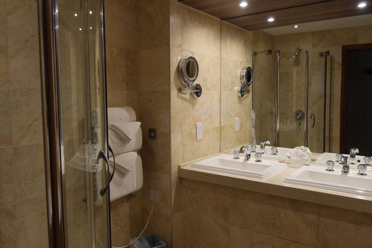 deluxe suite, 1 king bed, park view | bathroom | designer toiletries, hair dryer, towels, shampoo