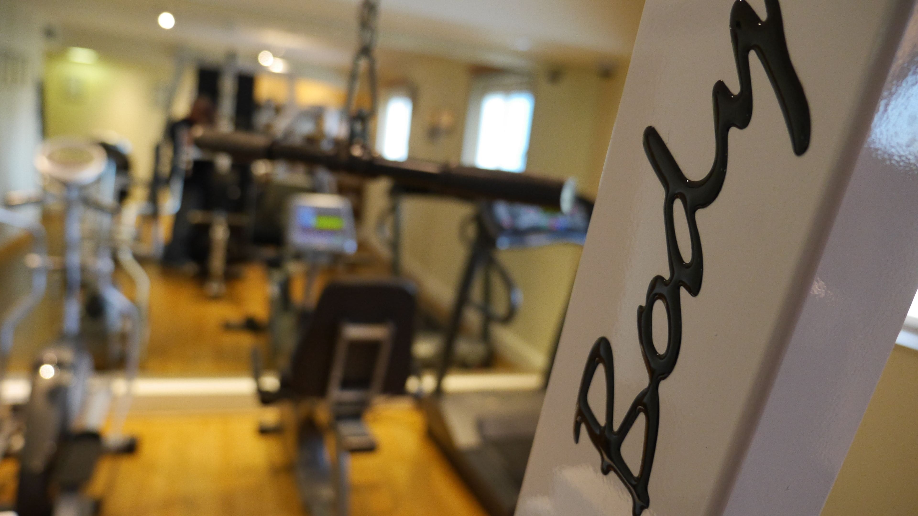 A gym with exercise equipment and a sign that reads "Badg".