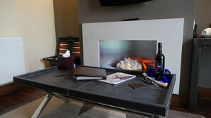 Una sala de estar moderna con chimenea, una mesita de centro y una botella de vino.